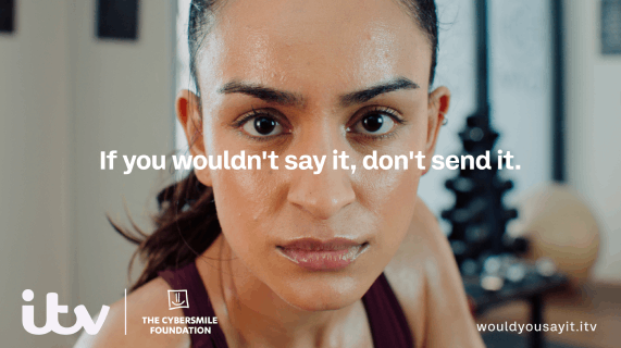 A young woman is making eye contact with the viewer. She looks perplexed. 'If you wouldn't say it, don't send it' is written over the centre of the image. ' hashtag WouldYouSayIt' bottom right. ITV and The Cybersmile Foundation logos bottom left.